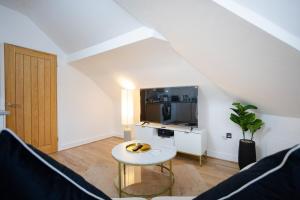 ein Wohnzimmer mit Fernseher und Tisch in der Unterkunft Modern 1-BR Apartment near Cardiff City Centre in Cardiff