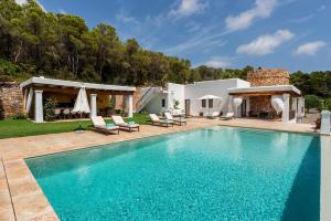 a swimming pool with chairs and a house at Llosas de Dalt in Sant Carles de Peralta