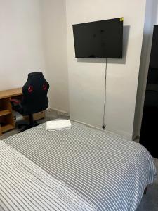 Schlafzimmer mit einem Bett und einem TV an der Wand in der Unterkunft Home from home in Southend-on-Sea