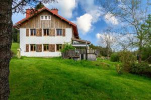 a house on a hill with a green yard at Gîte La Ramée in Ban-sur-Meurthe-Clefcy