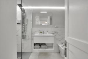 ein weißes Badezimmer mit Waschbecken und Dusche in der Unterkunft 7even in Corralejo + 34 Fotos