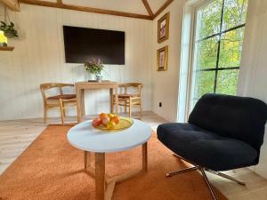 a living room with a table and a chair at Hällesdalens Gård - semesterhus i Bohuslän in Svenshögen