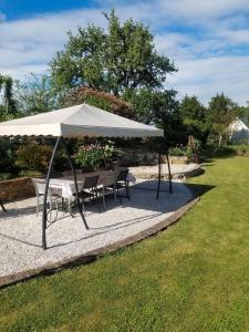 einen Tisch und Stühle unter einem weißen Schirm in der Unterkunft Gîte de la Mésange in Saint-Nicolas-des-Motets