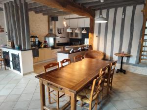 eine große Küche mit Holztisch und Stühlen in der Unterkunft Gîte de la Mésange in Saint-Nicolas-des-Motets