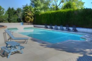 einen Pool mit Liegestühlen neben einer Hecke in der Unterkunft Gîte de la Mésange in Saint-Nicolas-des-Motets + 2 Fotos