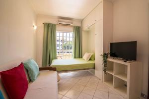 a living room with a bed and a television at Marjoh Al in Quarteira