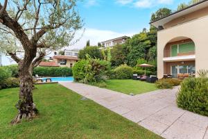 ein Haus mit einem Garten und einem Pool in der Unterkunft Dani Apartment garda lake view in Manerba del Garda
