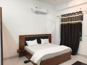 a bedroom with a bed and a window at Hotel Sanjay palace in Mahwah