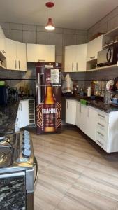 une cuisine avec une grande bouteille de bière sur le réfrigérateur dans l'établissement Pousada Uchimura, à Itapecerica da Serra