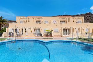 a large swimming pool in front of a building at Mangueros Suite 18 Puerto de Mogán in Puerto de Mogán