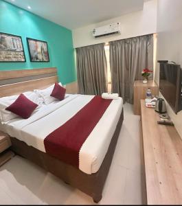 une chambre avec un grand lit et une télévision dans l'établissement Hotel Akasa Residency Near T-2 International Airport Mumbai, à Mumbai