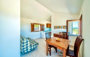 a kitchen and dining room with a table and chairs at ISA - Apartments with common swimming-pool and outdoor private area in Badesi in Badesi