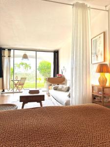 a bedroom with a bed and a living room at Casa Pombo SXM in Anse Marcel 