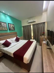 une chambre avec un grand lit et une télévision dans l'établissement Hotel Akasa Residency Near T-2 International Airport Mumbai, à Mumbai