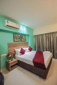 une chambre avec un grand lit avec des oreillers rouges dans l'établissement Hotel Akasa Residency Near T-2 International Airport Mumbai, à Mumbai