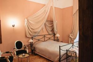 a bedroom with a canopy bed and a chair at Jaunpils pils in Jaunpils +13 photos