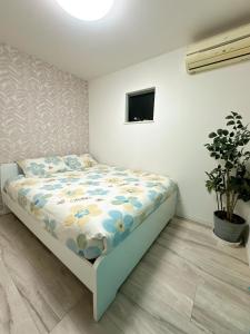 a bedroom with a bed in a room at Kasilin House in Osaka