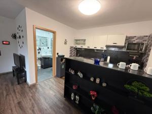 sala de estar con cocina con encimera en Homefeld Suite - Elegante und moderne Ferienwohnung zentral in Hünfeld bei Fulda mit Küche, kostenlosem Parkplatz und WLAN, en Hünfeld 7 fotos más