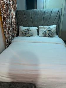 a bed with a headboard and two pillows on it at Home sweet home in Nairobi +3 photos