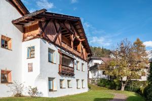 a white building with a wooden roof at Cesa Valeria App Sonia in Ortisei