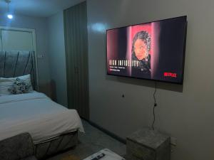 a room with a bed and a flat screen tv on the wall at Home sweet home in Nairobi