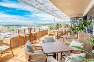 a restaurant with tables and chairs on a balcony at Sonesta Hotel Ibagué in Ibagué