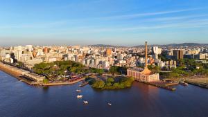 an aerial view of a city with a river and buildings at Xtay Cais Rooftop -Estúdios completos e Rooftop para o Rio Guaíba in Porto Alegre