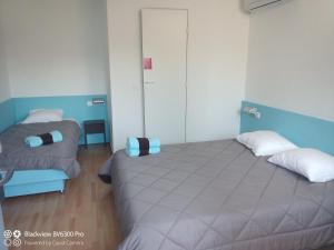 Montcaretにあるhôtel Montaigne Montcaretの青と白の部屋にベッドが2つある