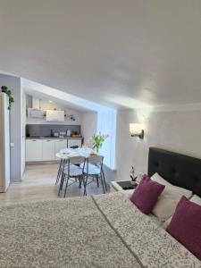 a bedroom with a bed and a table and a kitchen at Tukums apartments in Tukums