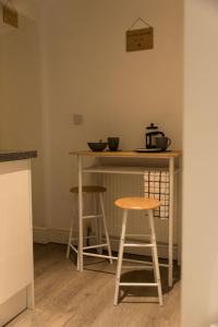 a kitchen counter with two stools and a table at Ballachulish - small double room nr Glencoe in Ballachulish