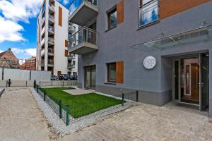 a building with a grassy yard in front of it at Perfect Apartment Oldtown Riverview Balcony in Gdańsk