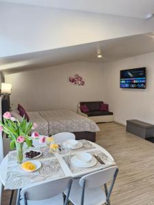 a living room with a table with chairs and a bed at Tukums apartments in Tukums