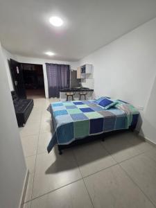 a bedroom with a bed and a living room at Apartaestudio 101 cómodo y Moderno in Tuluá