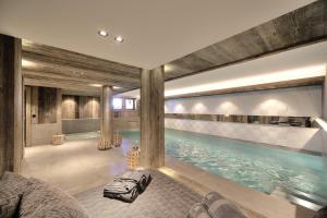a swimming pool in a building with a large pool at Chalet My World in Combloux