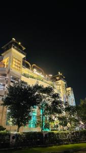 a building with a tree in front of it at night at Luxe Homes 1Bhk Luxury AirB&B Flat in Mohali +35 photos