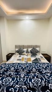 a bedroom with a blue and white bed with pillows at Luxe Homes 1Bhk Luxury AirB&B Flat in Mohali