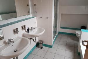 Klein GelmにあるDünenresidenz Glowe Dünenresidenz Glowe A 31の洗面台2つとシャワー付きのバスルーム +8枚の写真