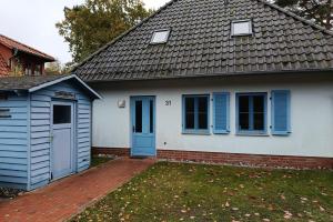 Klein GelmにあるDünenresidenz Glowe Dünenresidenz Glowe A 31の青い扉と庭のある白い家