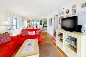 a living room with a red couch and a tv at Waikiki #302 in Ocean City