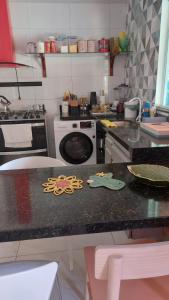 a kitchen with a counter with a stove and a sink at Casa Pé na Areia in Barra Grande