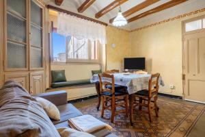 un salon avec une table, des chaises et une télévision dans l'établissement Ca Cedó, à Serra de Almós