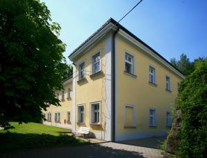 a large yellow building with a bench in front of it at Depandance Vodoléčba in Lázně Libverda