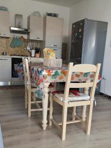 cocina con mesa con 4 sillas y cocina en La Casa dei Pioppi, en Ficarolo