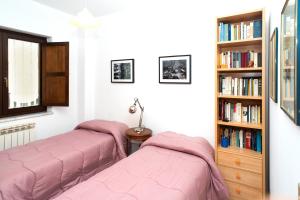 a bedroom with two beds and a book shelf at Xenia in Castrovillari +24 photos