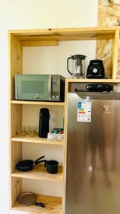 a kitchen with a refrigerator and a microwave on a shelf at Ilha de Boipeba Casa com 2 quartos com ar condicionado no 1ºandar in Cayru