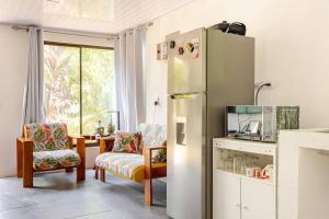 een keuken met een koelkast en een tafel met stoelen bij Private Costa Rican Oasis with Pool River Views in Montezuma