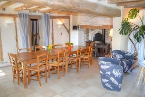 eine Küche und ein Esszimmer mit einem Holztisch und Stühlen in der Unterkunft Domaine de la Picardière in Saint-Nicolas-des-Motets