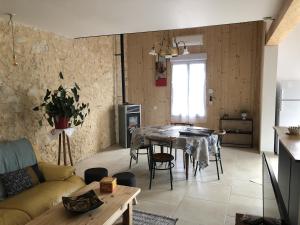 una sala de estar con una mesa y un sofá en Logement Pascal, en Villeneuve-sur-Lot