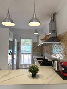eine Küche mit drei Lichtern und einer Pflanze auf einer Theke in der Unterkunft Sunshine Courtyard, Villa independiente en Valencia in Lliria