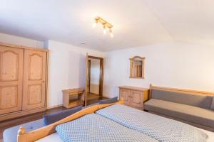 a bedroom with a bed and a couch at Schwüwong - Apartment 01 in Kelchsau